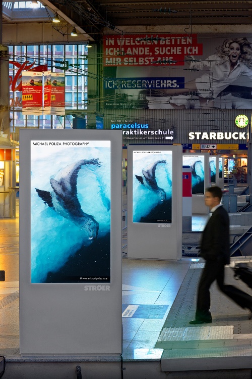 Foto: Bildschirm-Stelen mit Werbung an Bahnhof in München; copyright: Ströer...