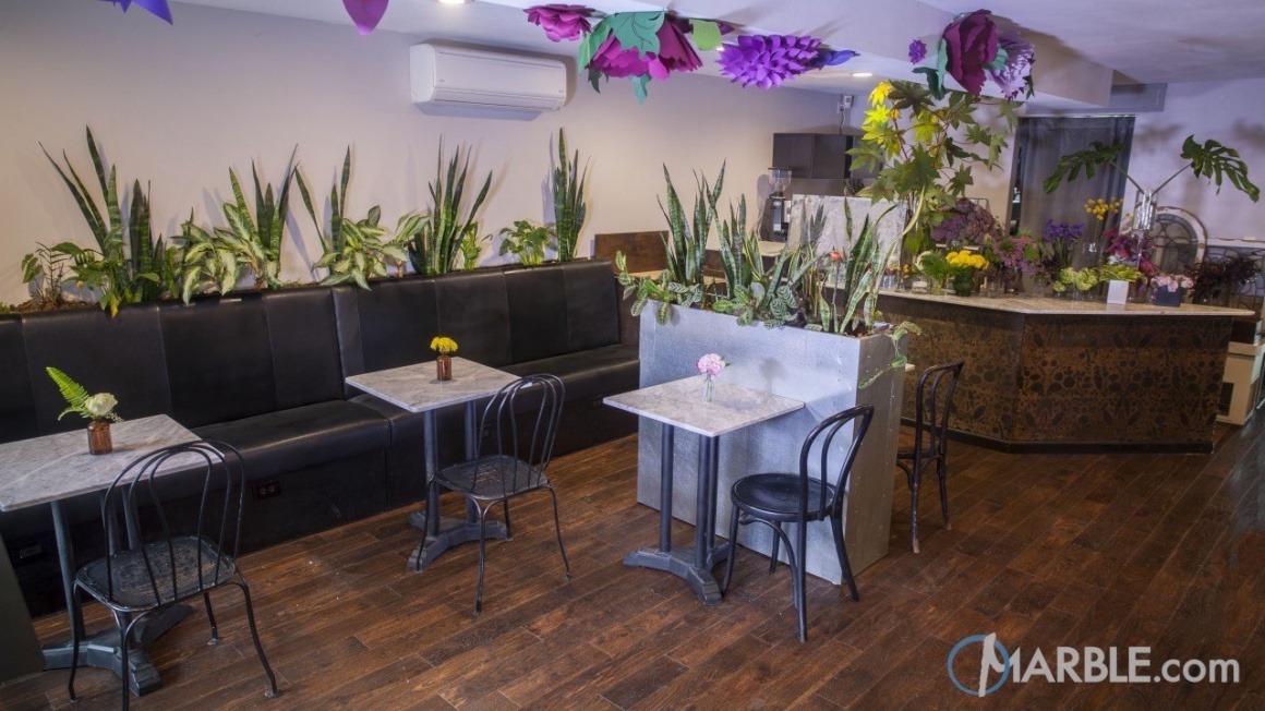 coffee bar section of a New York flower shop with marble counters and tables...