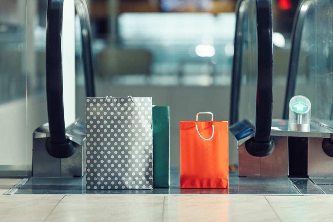 Two shopping bags standing on the top of a moving staircase; copyright:...