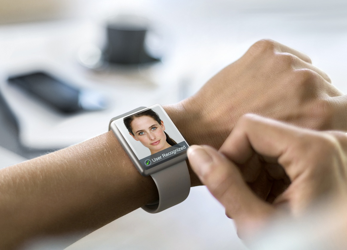 Smart watch on an arm with a human face on the display; copyright: Osram...