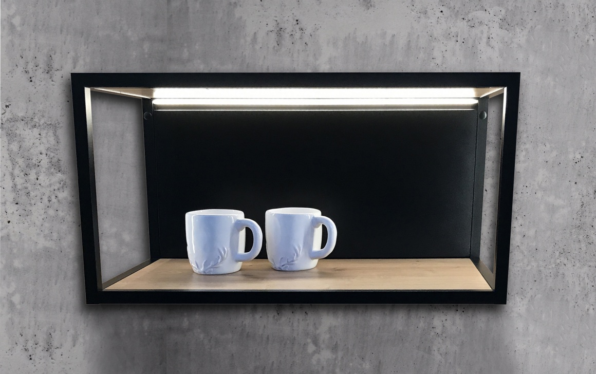 Metal shelf on concrete wall with lighting and two cups...