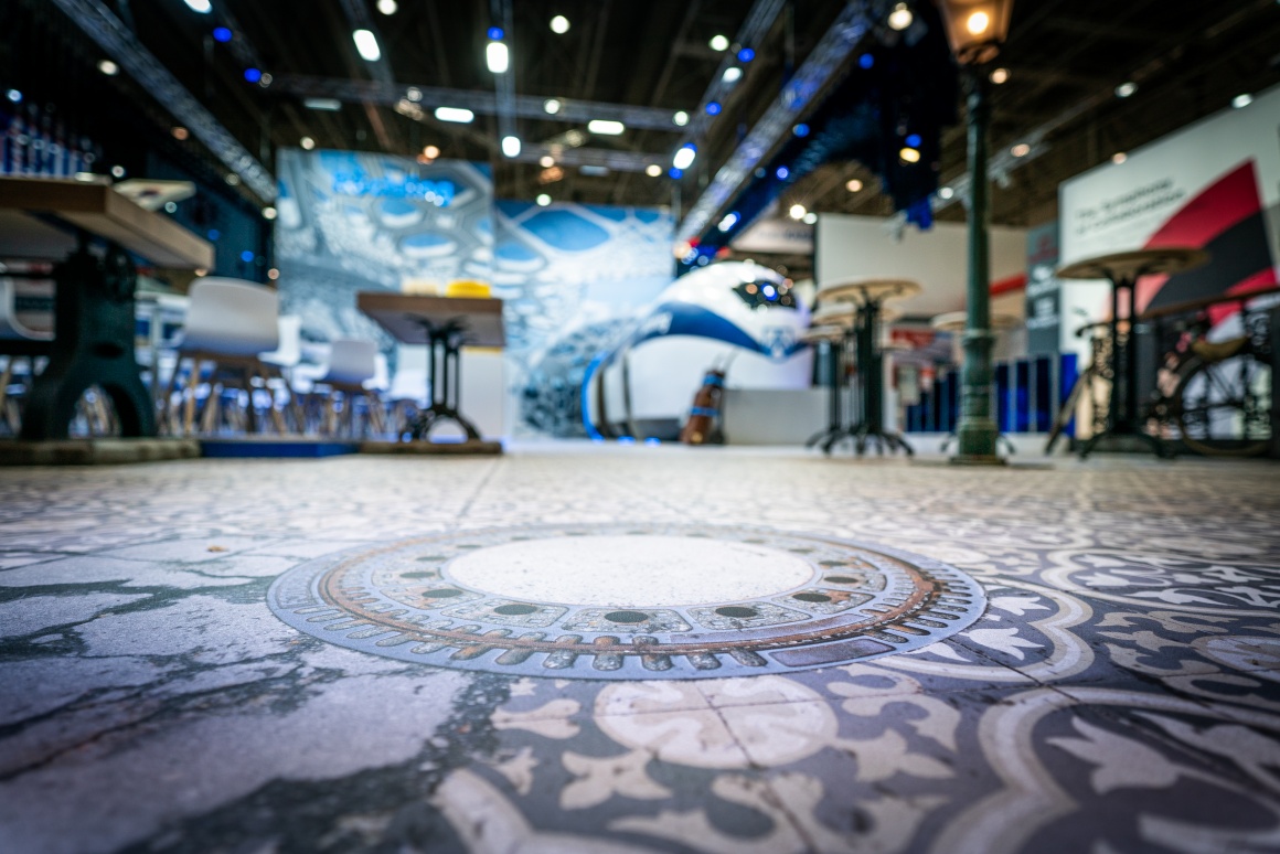 A printed floor in an exhibition hall with the visual of a manhole cover...