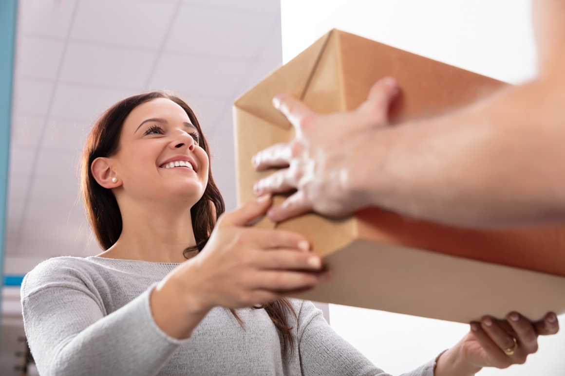 Woman is taking a package from a delivery person, photographed from below...