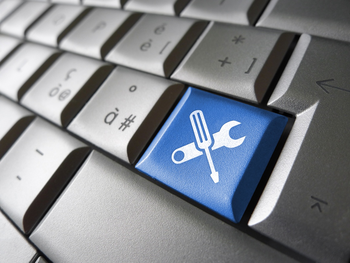 A grey keypad with a blue key with symbols of tools on it...