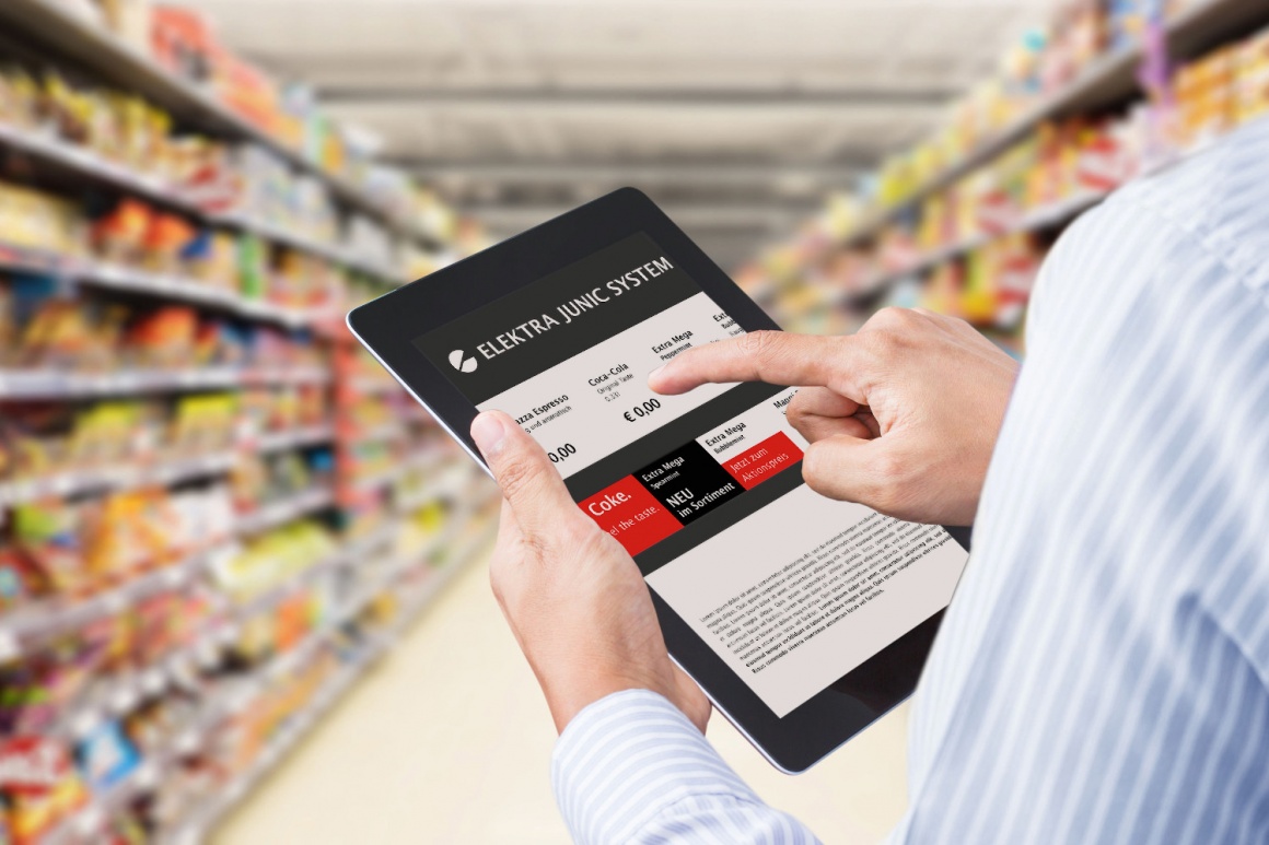 Person operates a tablet in a supermarket between shelves...