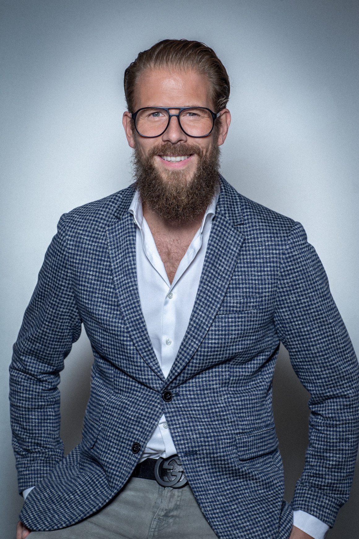 A man in a jacket with beard and glasses