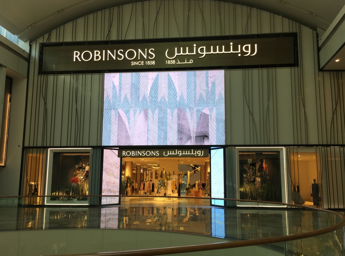 A large digital signage screen around a shop entrance...