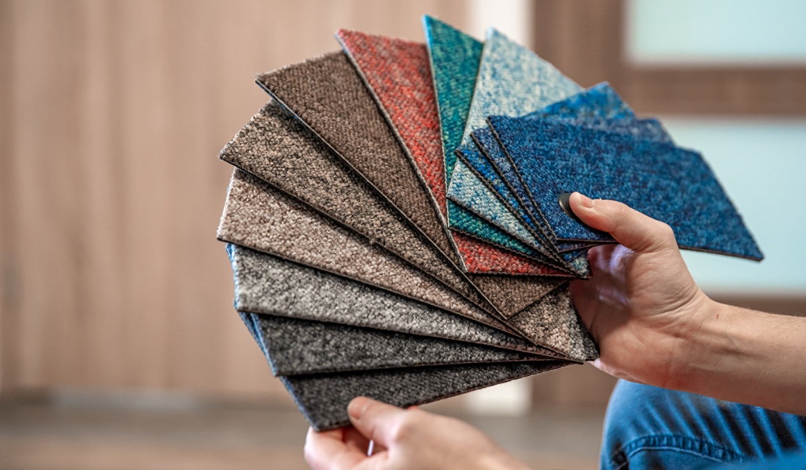 Two hands hold carpet samples in different colours