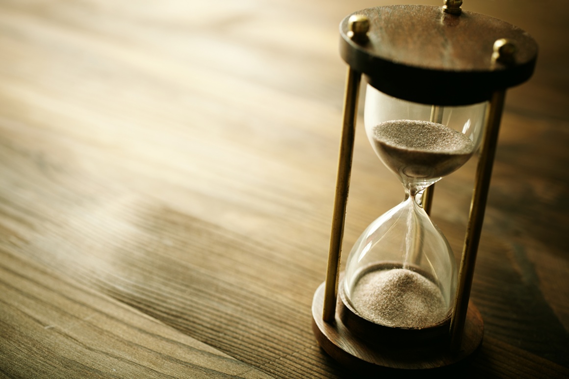 An hourglass on a wooden table