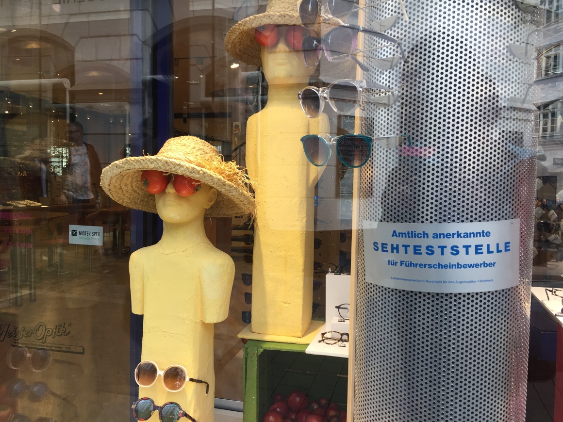 Two mannequins with straw hats and tomatoes over their eyes, glasses displayed...