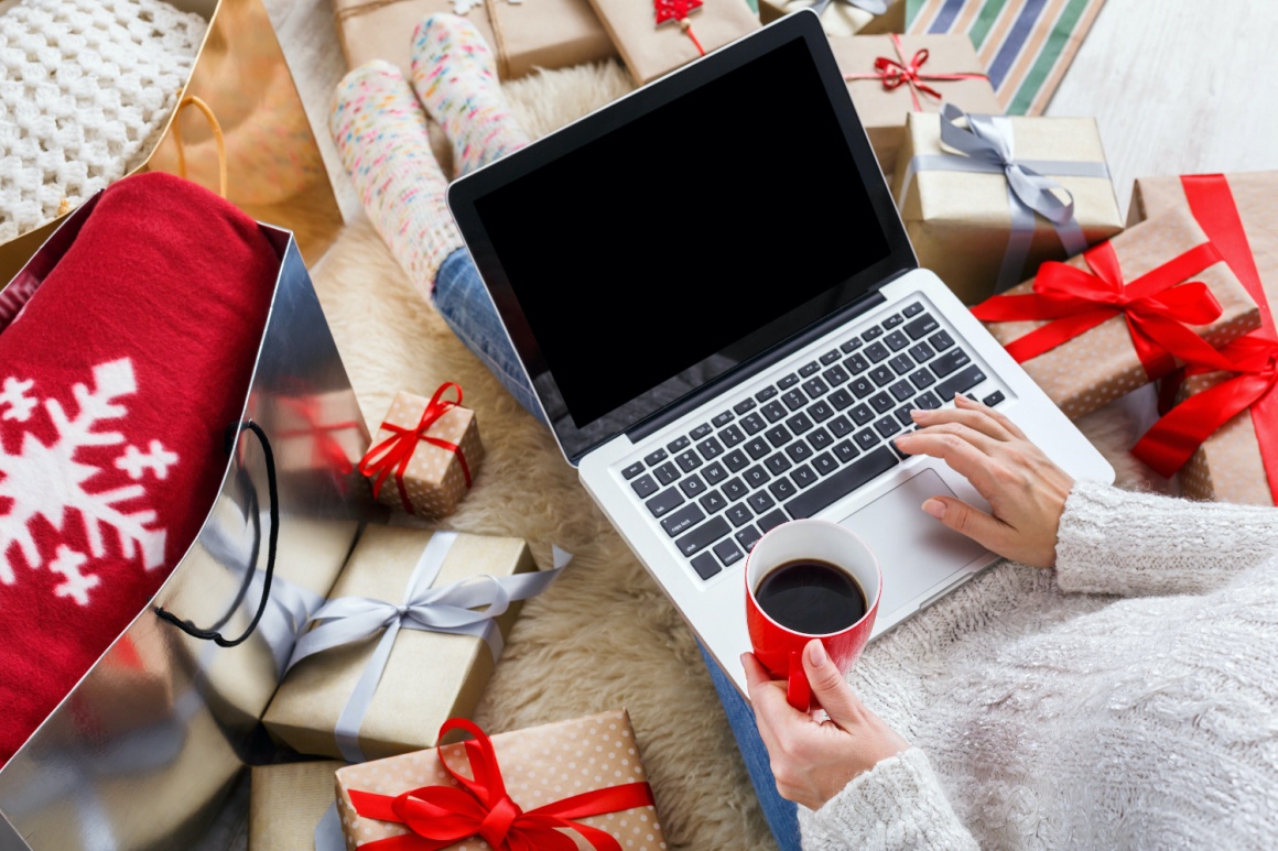 One person at the laptop with red coffee cup and Christmas decoration around it...