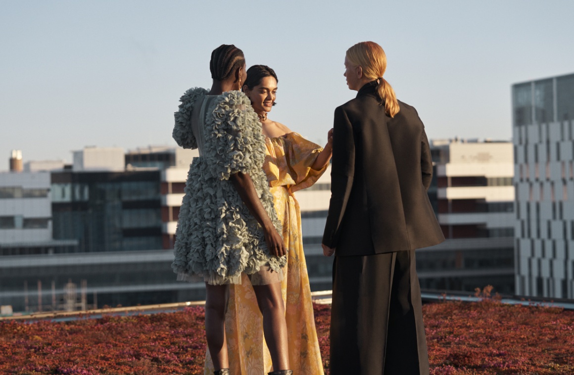 Three female models are standing on a roof top