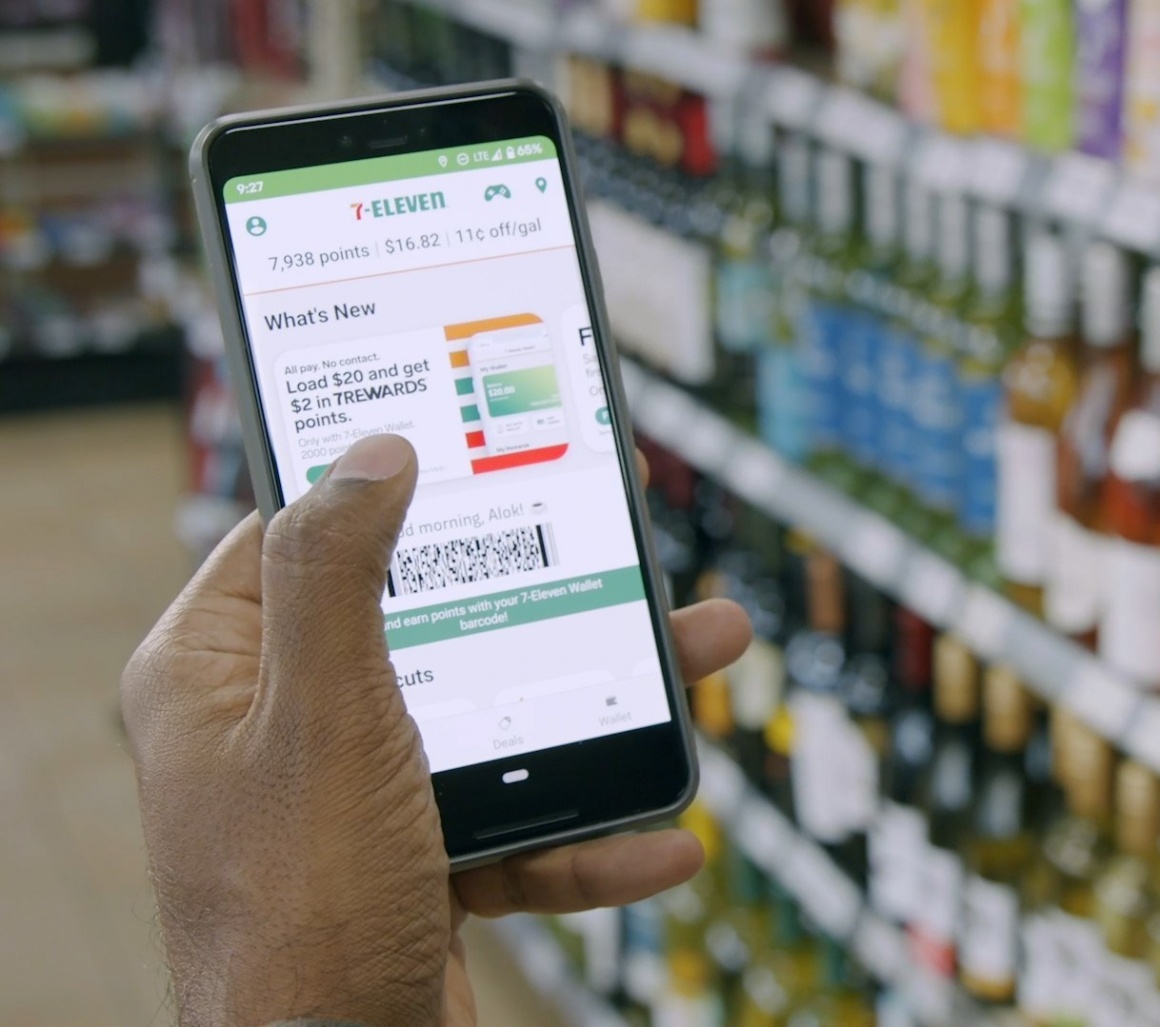 A hand holding a smartphone with an app in a store