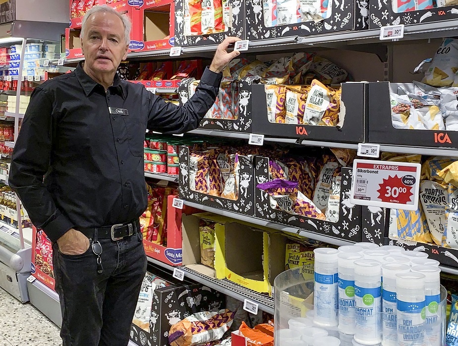 Owe Krook, the shop owner, stands before the newly outfitted store shelves...