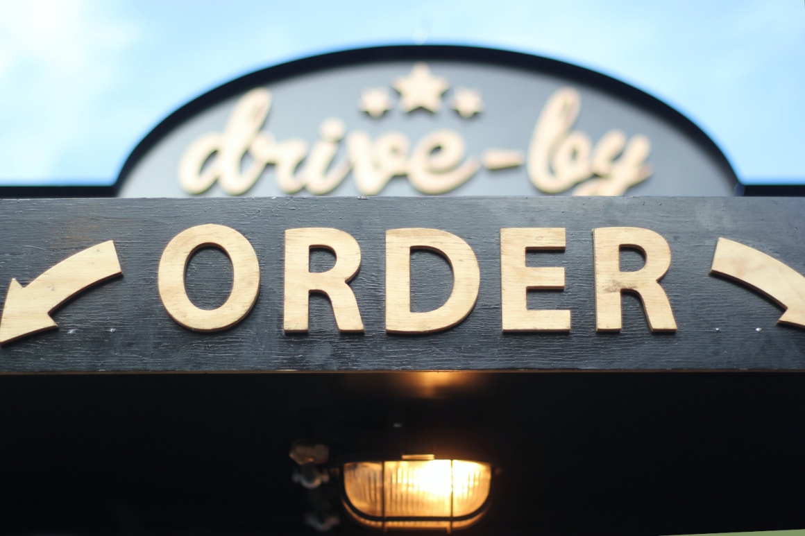 A sign at a roof saying “Drive-by” and “order”...