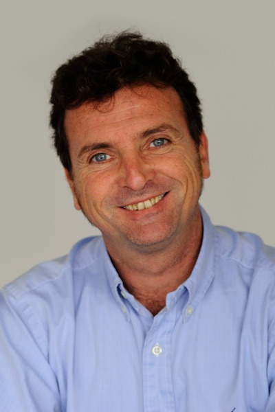 A man in a blue shirt smiling into the camera.