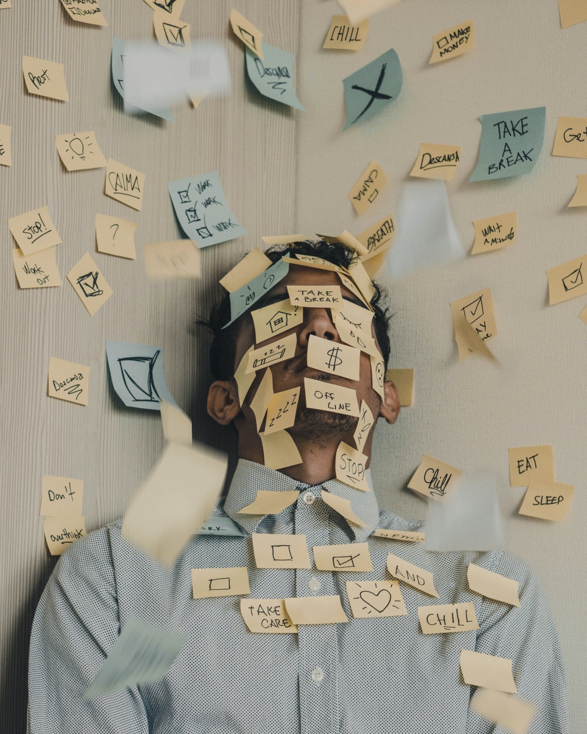 A man in the corner of a room full of written sticky notes...