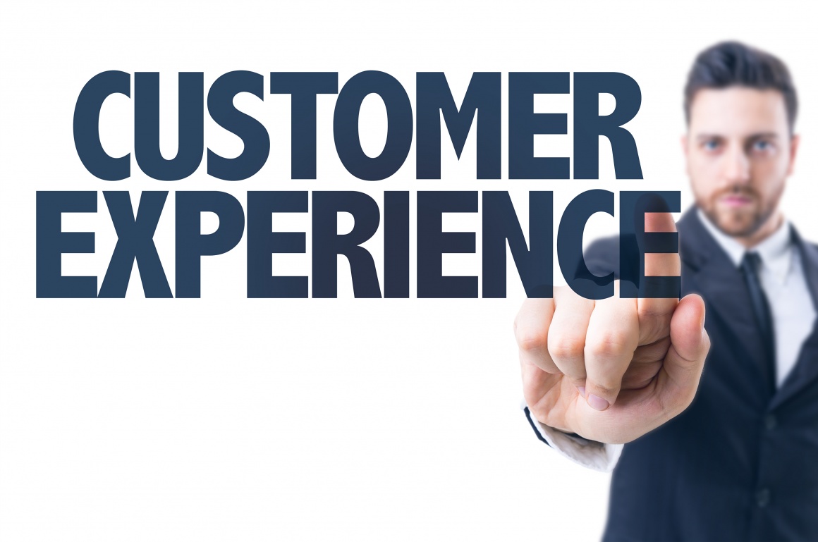 A man in a suit points his finger at the text Customer Experience...